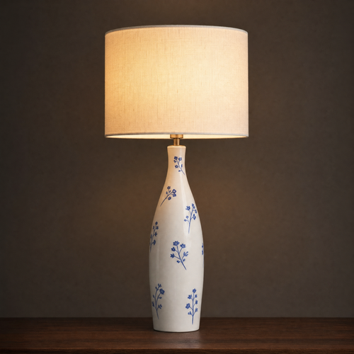 Lit ceramic table lamp with a tall slim bottle base painted with scattered cobalt blossom sprigs